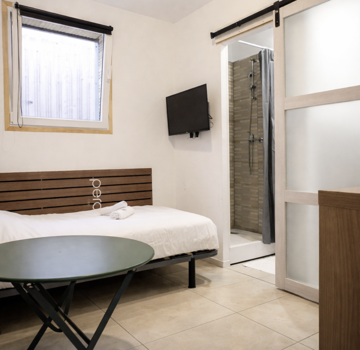 Chambre moderne d’appart-hôtel idéale pour le tourisme à Dieppe, avec lit confortable, télé, douche privative et lumière naturelle.